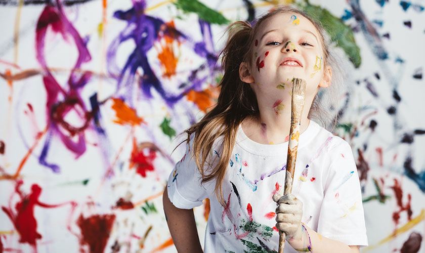 child holding paint brush